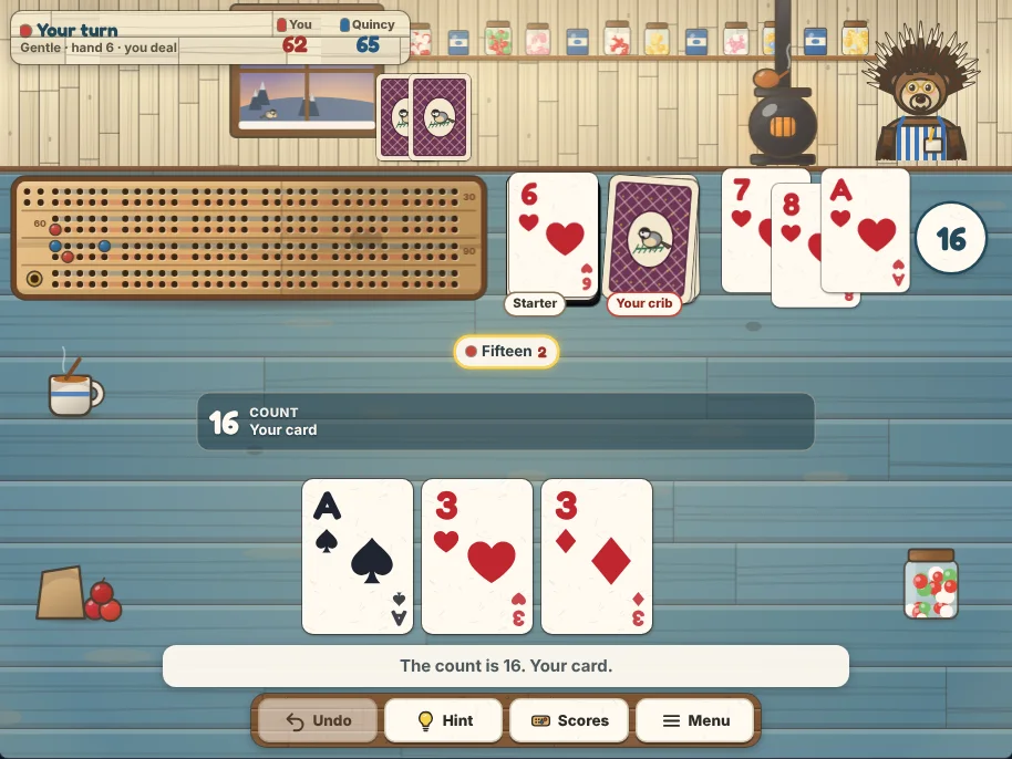 Actual Chickadee Hill Cribbage gameplay on a desktop browser: a painted blue table in a country store, Quincy the porcupine and his cards across the top, the wooden cribbage board with red and blue pegs beside the deck, the starter and the crib, the cards played so far with the running count, your hand along the bottom, and Undo, Hint, Scores and Menu on the shelf below.