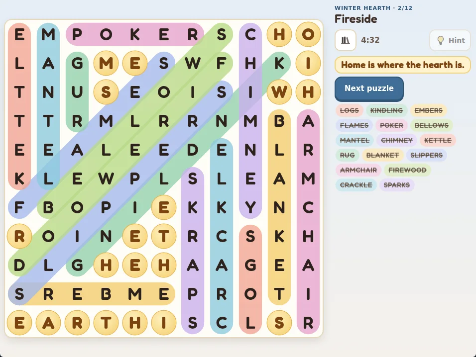 Actual Cottage Word Search grid after finishing the Fireside puzzle from the Winter Hearth book: an 11 by 11 grid with every word in a colored capsule, the leftover letters circled in gold, and the saying “Home is where the hearth is.” written out beside the grid above a Next puzzle button and the struck-through word list.