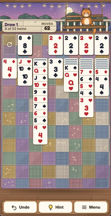 Actual Porch Swing Solitaire gameplay on a phone-sized screen: Biscuit the ginger cat on his porch swing under the roof beam, the move counter, the stock, the waste and the four foundations in a row across the quilt, seven narrow columns of cards below them, and Undo, Hint and Menu on a wooden bench at the bottom.