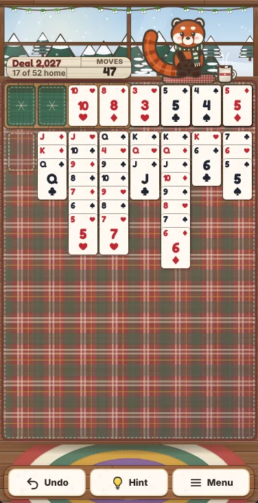 Actual Snowberry Cabin Solitaire gameplay on a phone-sized screen: the same deal 2,027 position, with the free cells and foundations in one row above the eight columns, Undo, Hint and Menu below, and Maple on the window sill with her mug of cocoa.