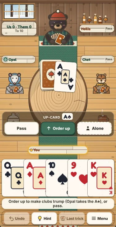 Actual Sugar Camp Euchre gameplay on a phone held upright: Hollis the black bear at the top of the sugarhouse with the score sign and his name plate on either side, Opal the opossum and Chet the chipmunk at the sides under their name plates, the kitty and the up-card on the log slab, the bidding panel with Pass, Order up and Alone across the table, your five cards in one row, and the message line and the Undo, Hint, Last trick and Menu buttons at the bottom.